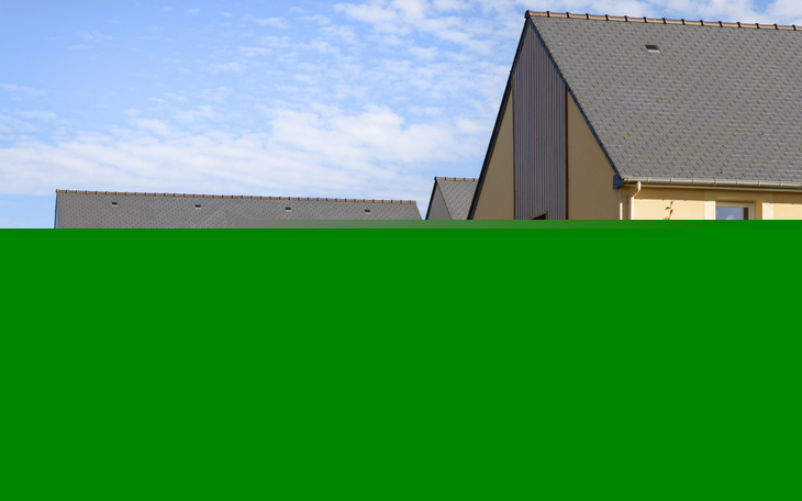 Moderne Häuser mit Gärten unter blauem Himmel.