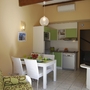 Kleine Küche mit Esstisch und grünen Akzenten in einem Ferienapartment.