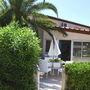 Ferienhaus mit Terrasse, Sonnenschirm und Palme in St. Cyprien Plage.