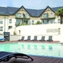 Swimmingpool vor einem Hotel mit mehreren Etagen und Balkonen.