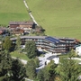 Luftaufnahme eines Chalet-komplexes mit mehreren Gebäuden in einer grünen Landschaft.