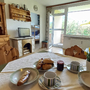 Essbereich in Appartement mit gedecktem Tisch und Ausblick auf Balkon und Garten.