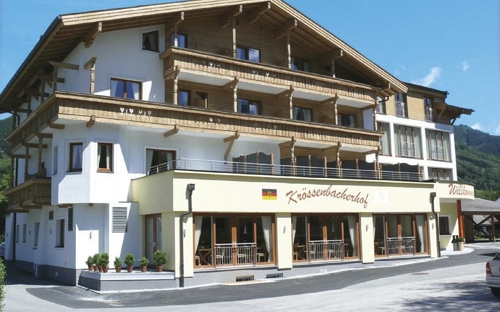 Gebäudefront eines Gästehauses mit Holzverkleidung und Balkonen.