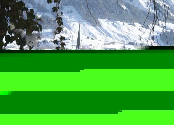 Verschneite Dorfansicht mit Kirche in winterlicher Berglandschaft.