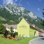 Außenansicht des Erzberg Alpin Resorts vor bewaldeten Bergen.