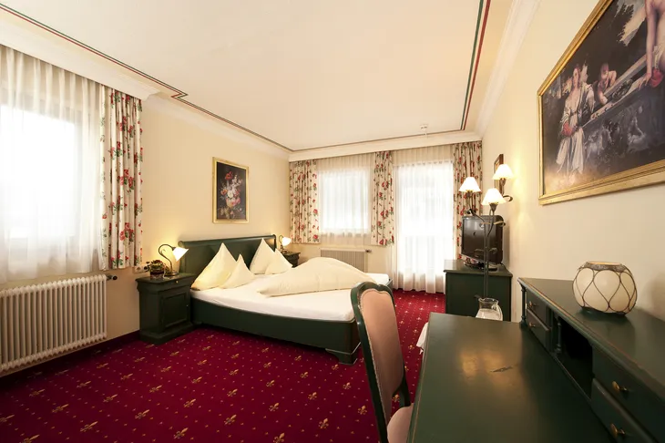 Doppelzimmer mit rotem Teppich und klassischen Möbeln im Hotel Eschenhof.