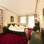 Doppelzimmer mit rotem Teppich und klassischen Möbeln im Hotel Eschenhof.