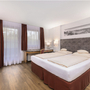 Standard-Doppelzimmer mit zwei Betten, Schreibtisch und roter Einrichtung.