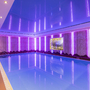 Innenpool des Hotels Alpenrose mit violetter Beleuchtung und Bergwandbild.
