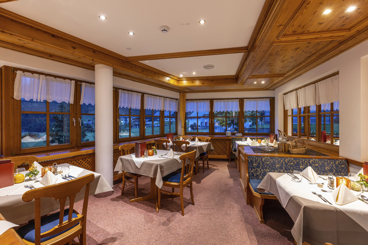 Gemütliches Restaurant mit gedeckten Tischen und alpenländischem Stil.