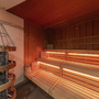 Innenansicht einer Sauna mit Holzverkleidung und Sitzbänken.