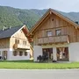 Zwei Holzhäuser vor bewaldetem Berg in Obertraun.