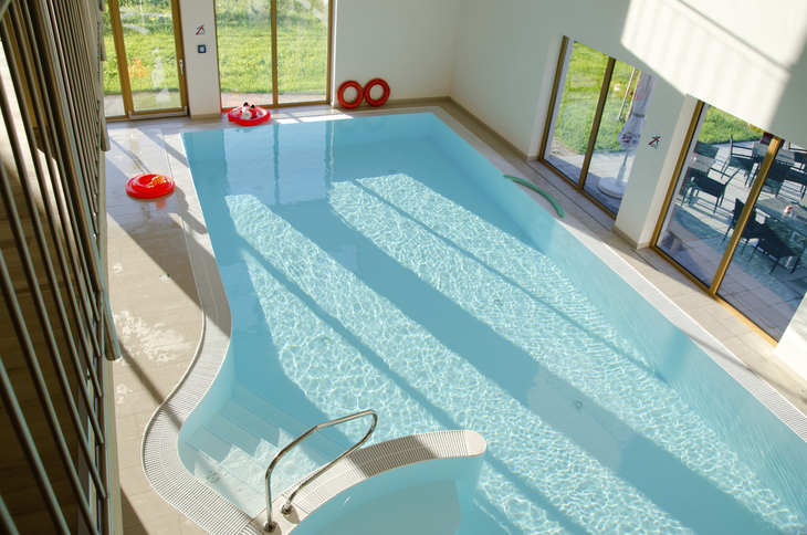 Innenpool mit großen Fenstern und rotem Rettungsring.