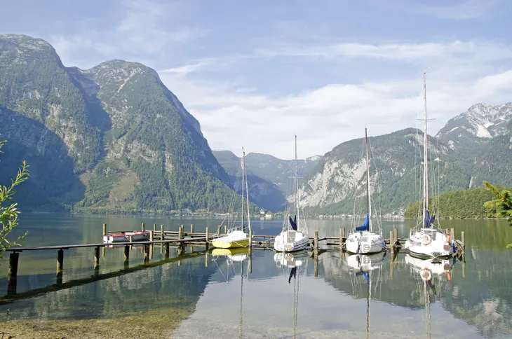 Boote an einem Steg, umgeben von Bergen und einem See in Obertraun.