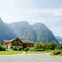 Holzhaus mit Bergkulisse in Obertraun bei klarem Himmel.