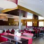 Restaurant mit roten Stühlen und eingedeckten Tischen.