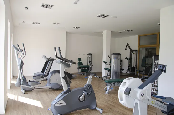 Fitnessraum mit verschiedenen Trainingsgeräten.