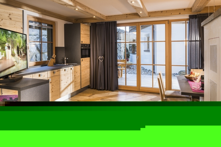 Gemütliches Interieur eines Ferienhauses mit Holzverkleidung und großen Fenstern.