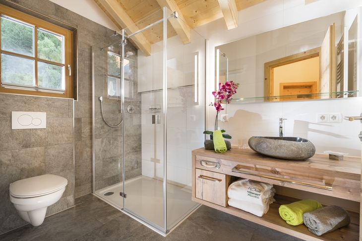 Modernes Badezimmer mit Dusche und Waschtisch aus Holz.