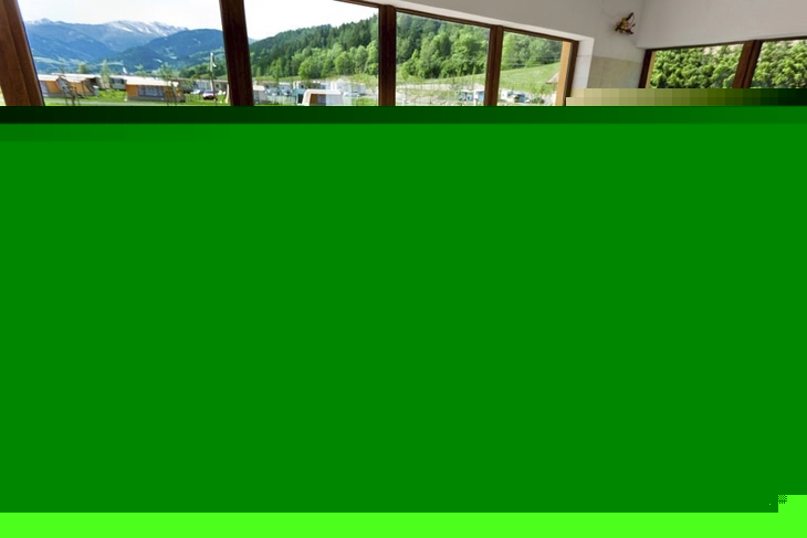 Personen entspannen in Liegestühlen in einem Raum mit Blick auf einen Pool und Berge.
