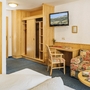 Komfortable Hotelzimmeransicht mit Holzmöbeln und Sofa in warmen Farben.