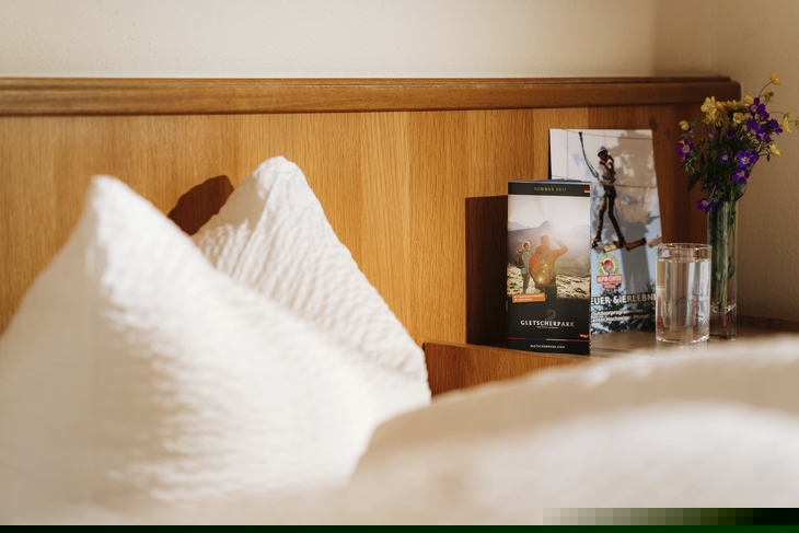 Hotelzimmer mit bequemen Kissen und Bücherregal im Hintergrund.