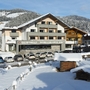 Winterliche Ansicht eines Hotels in Wagrain, umgeben von verschneiten Bergen.