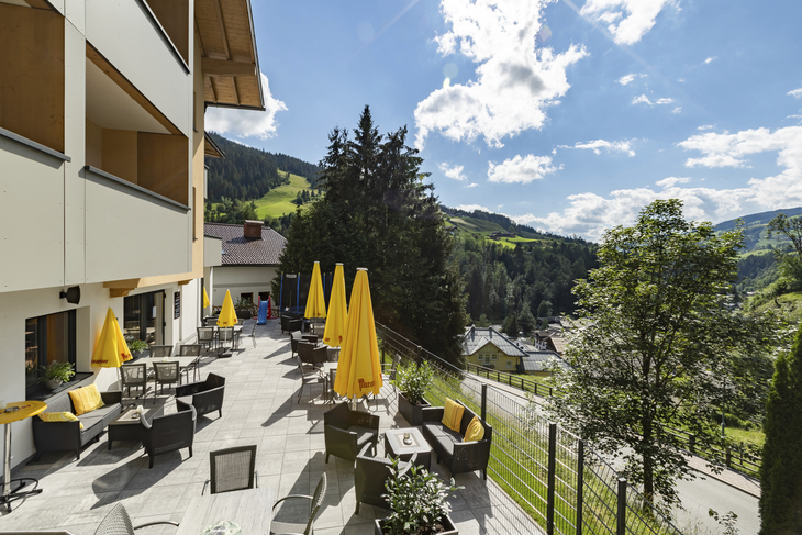 Terrasse des Wanderhotels Erika mit Blick auf die Berge in Wagrain bei Sonnenschein.