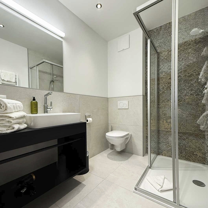 Modernes Hotelbadezimmer mit Dusche, Waschbecken und Toilette.