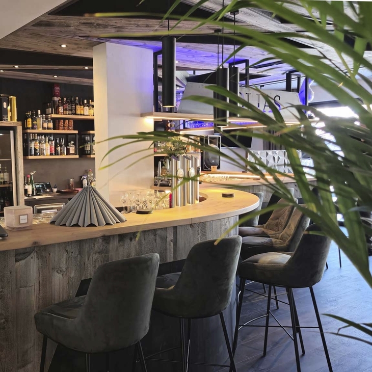 Barbereich mit moderner Einrichtung und hohen Stühlen im Hotel Erika.