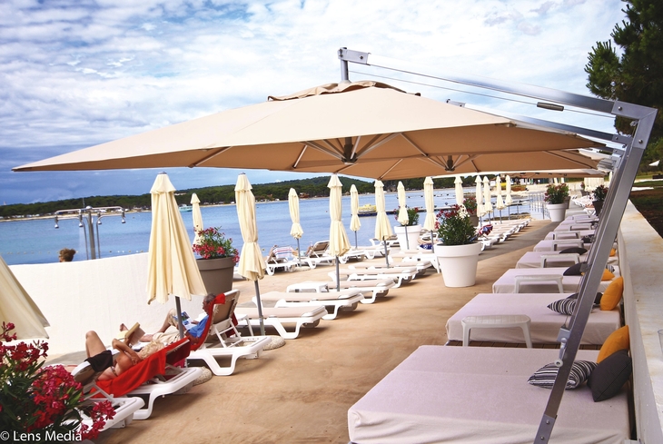 Sonnenliegen und Sonnenschirme am Strand des Belvedere Hotels in Pula.