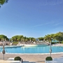 Poolbereich des Belvedere Hotels mit Liegestühlen und Bäumen im Hintergrund.