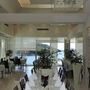 Innenansicht eines eleganten Restaurants mit gedeckten Tischen und Meerblick.