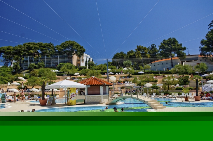 Poollandschaft des Belvedere Resorts in Vrsar mit Schwimmern und Sonnenschirmen.
