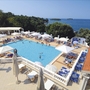Resort-Poolbereich mit Liegestühlen und Blick aufs Meer.