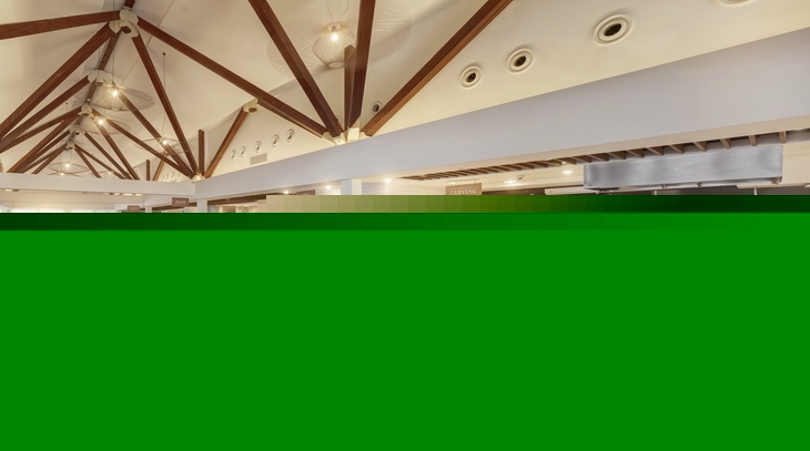 Helles Restaurant mit Buffets und Holzbalken an der Decke.