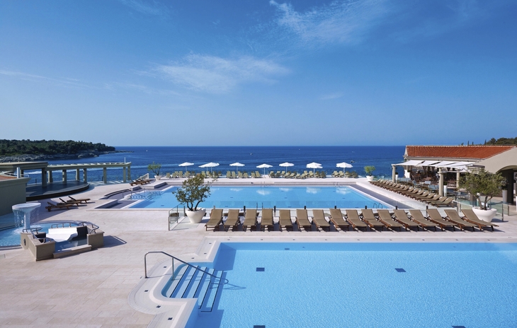 Poollandschaft mit Liegestühlen und Meerblick im Park Plaza Verudela Resort.