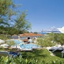 Blick auf Poolbereich des Resorts Belvedere mit Sonnenschirmen und Liegen im Vordergrund.