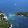 Luftaufnahme einer Küstenlandschaft mit Brücke und bewaldeter Insel.
