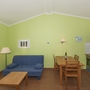 Wohnzimmer mit blauer Couch, Esstisch und offener Küche.