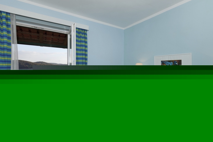 Hotelzimmer mit Doppelbett und Balkon mit Meerblick.