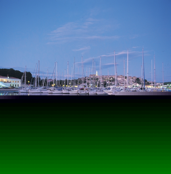 Segelboote im Hafen von Vrsar bei Sonnenuntergang, ruhiges Wasser und klarer Himmel.