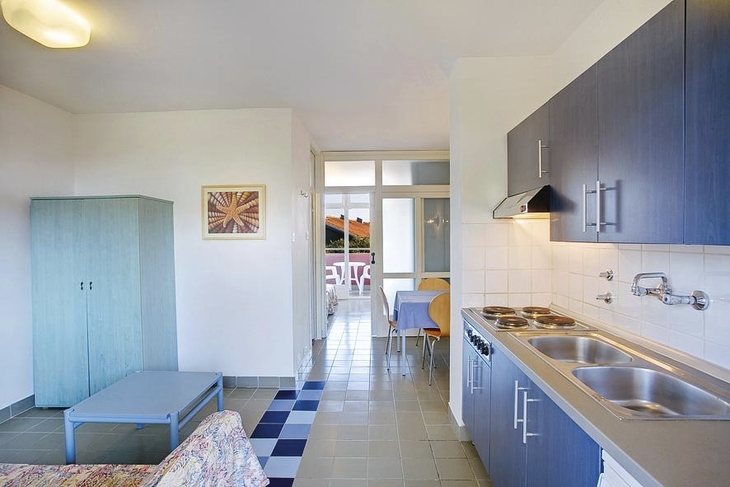 Kompakte Ferienwohnung mit Küche, Esstisch und modernem Mobiliar.