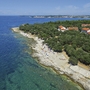 Luftaufnahme eines Küstengebiets mit Strand und Ferienanlage in Poreč, Kroatien.
