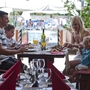 Familie genießt Essen in einem Restaurant mit Blick auf den Pool.