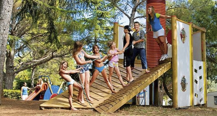 Kinder spielen auf einem Spielplatz im Freien auf einem Campingplatz.