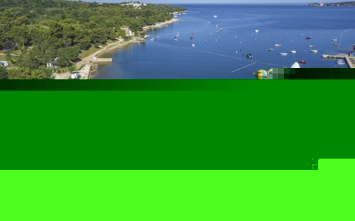 Luftaufnahme eines Strandes mit Liegestühlen und einem Wasserpark auf dem Meer.