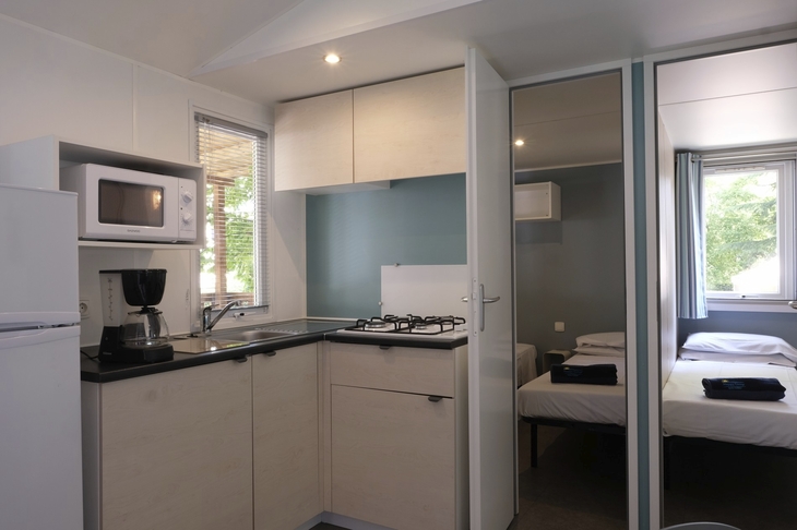 Kompakte Küche und Schlafzimmer in einem modernen Mobilheim.