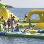 Personen spielen auf einem aufblasbaren Wasserpark im Meer.