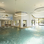 Innenpool im Hotel mit großen Fenstern und modernen Leuchten.